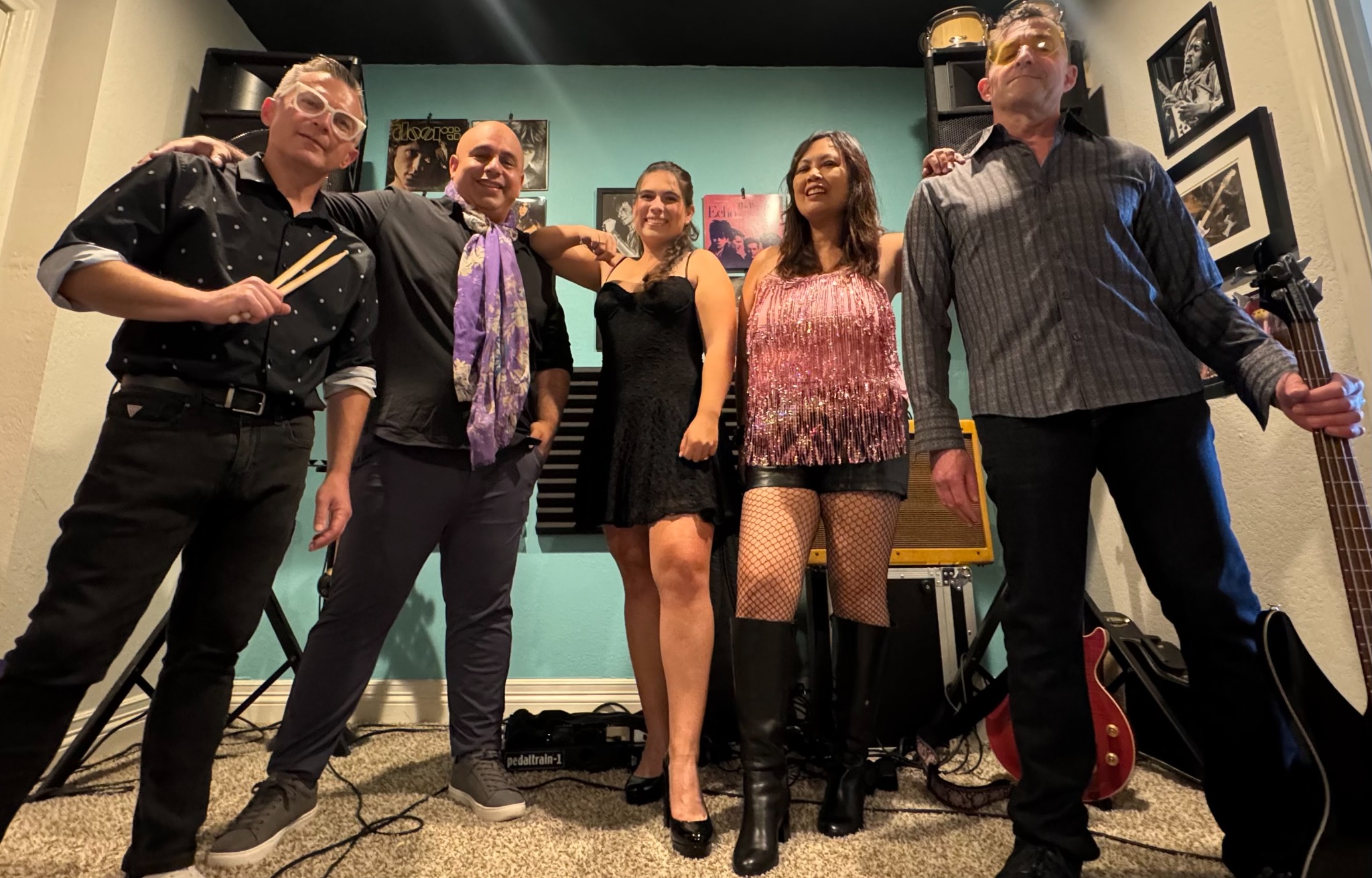Full band lineup posing in the rehearsal room